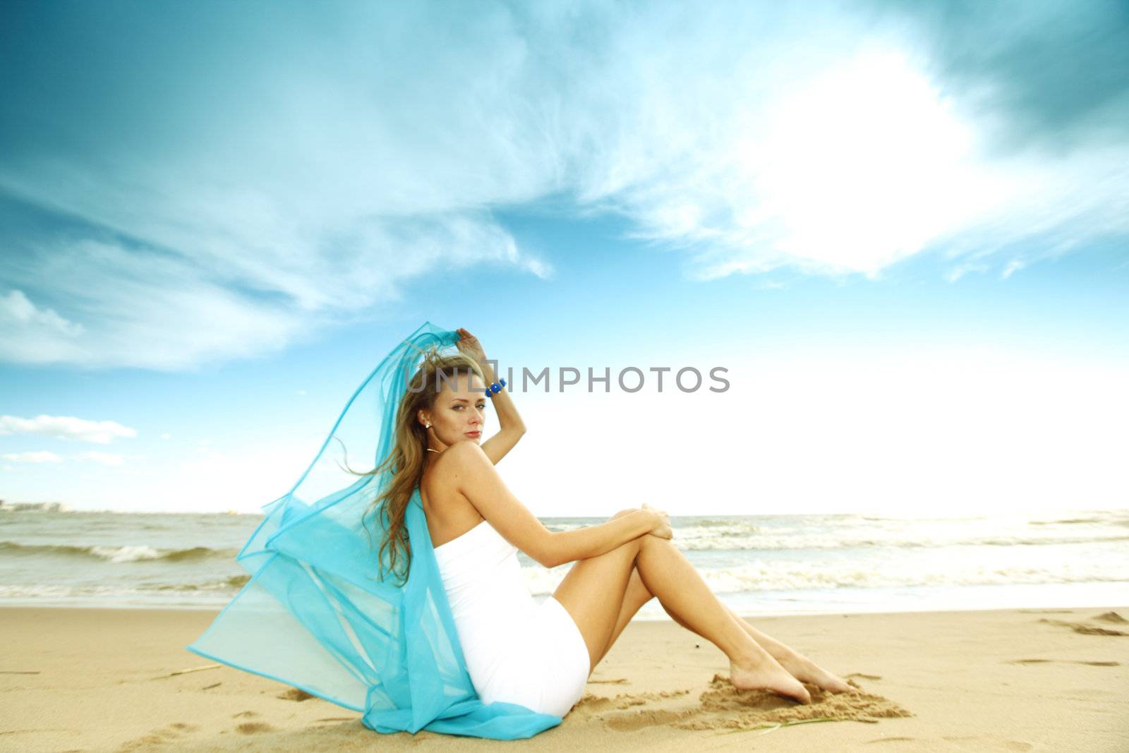 woman laying on sand sea on background