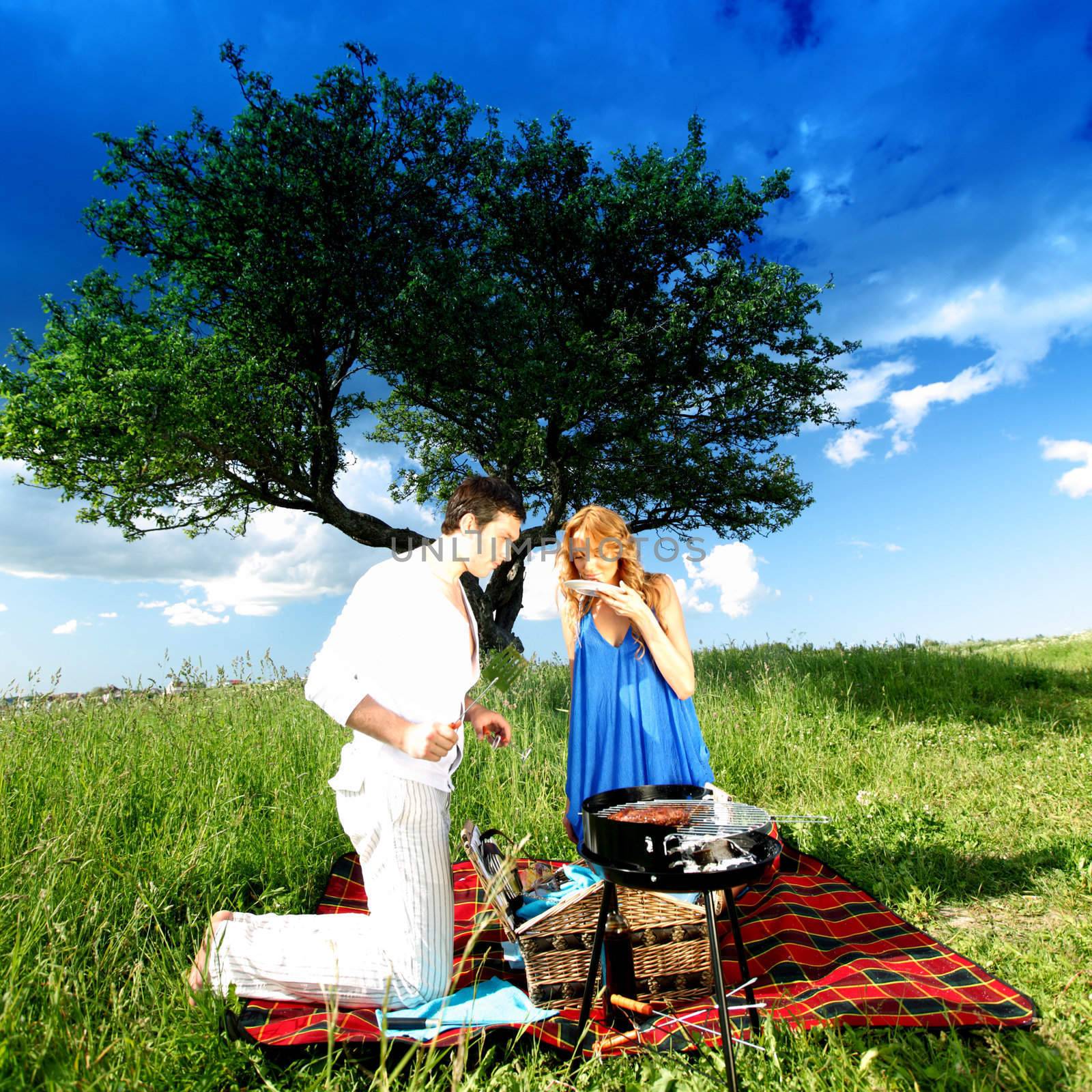 man and woman on picnic in green grass