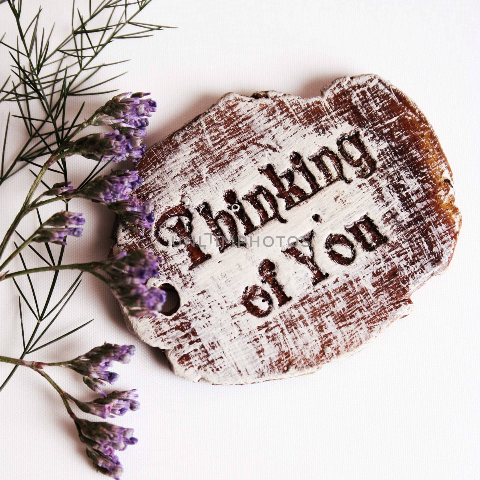 The words Thinking Of You engraved on a small wooden plaque