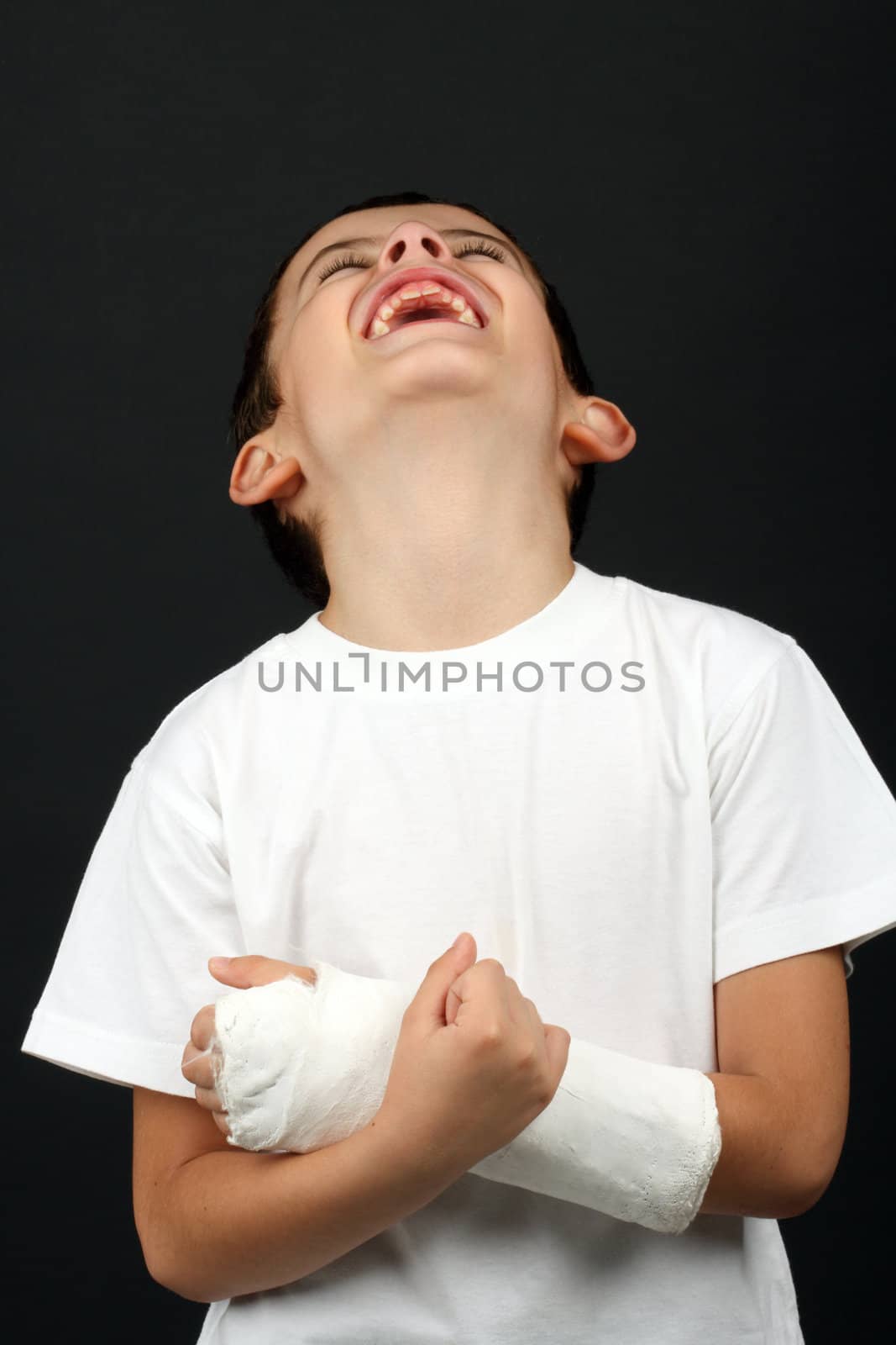 Boy with broken hand in cast, over black