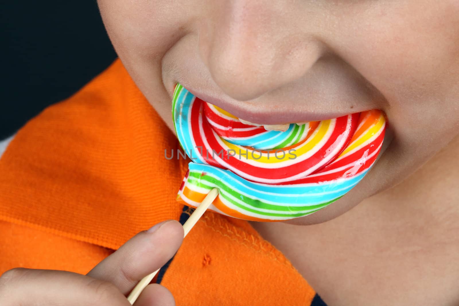 Boy eating lollipop close up