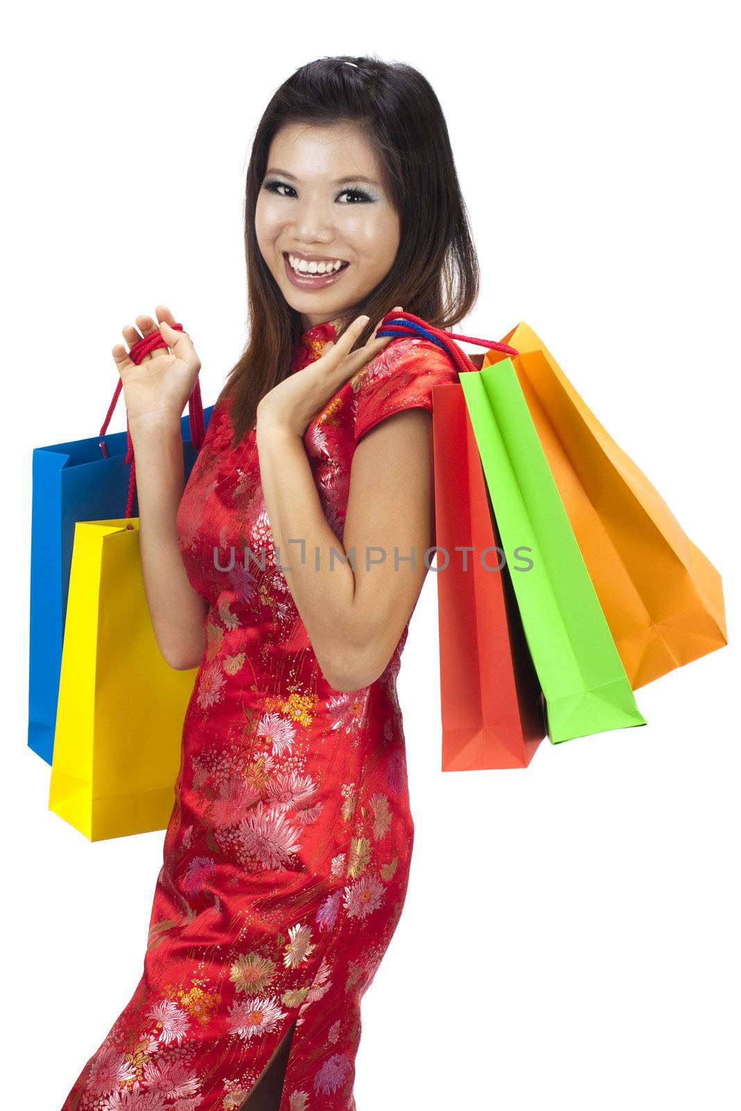 Woman in tradition Cheongsam holding colorful shopping bag.