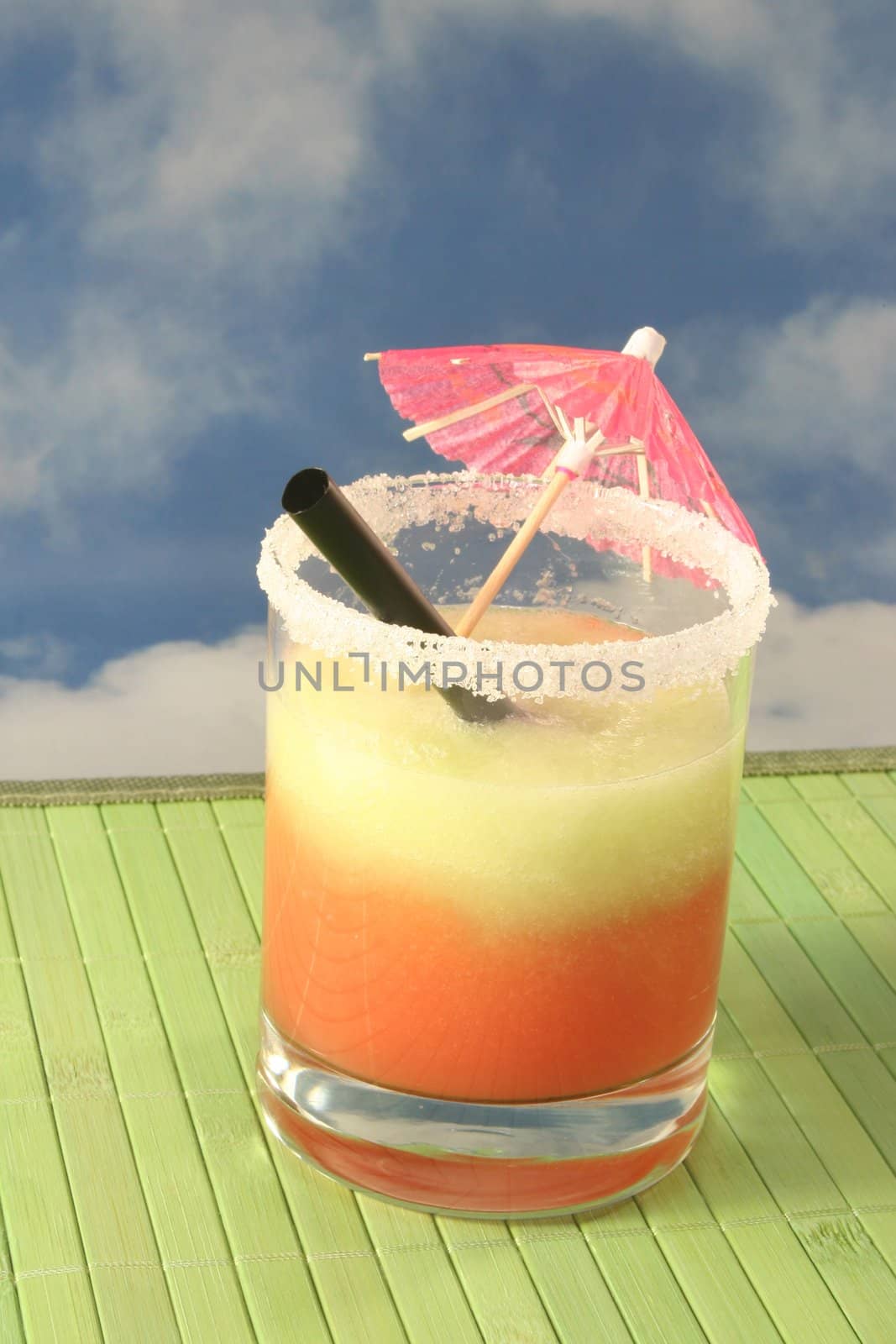 Glass melon smoothie with a straw and umbrella
