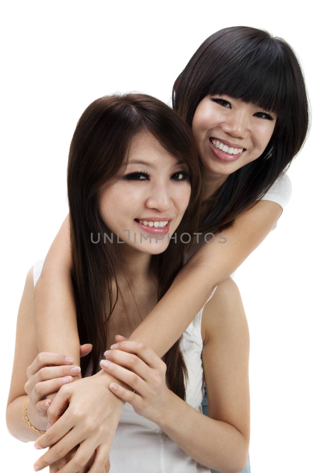 Two young Asian sisters on white background