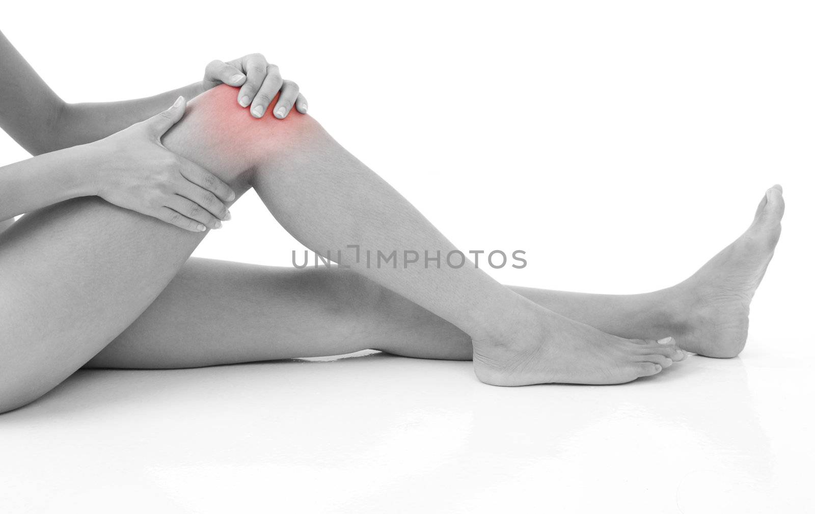 Woman holding on sore knee isolated on white.