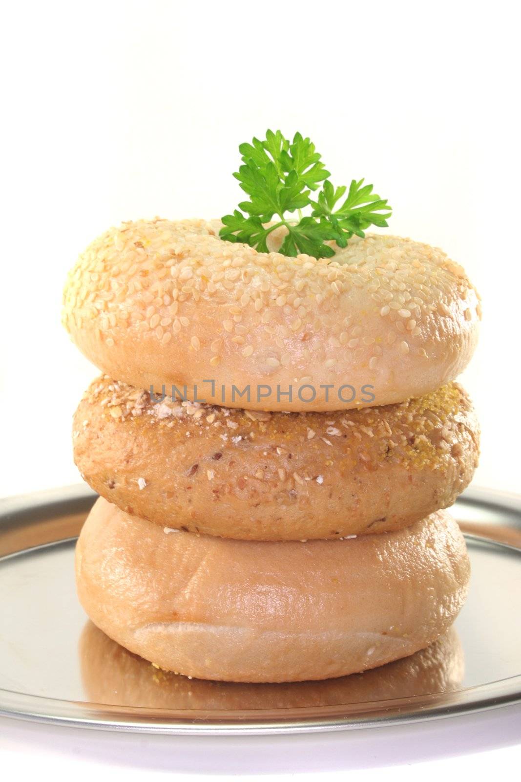 three bagel with parsley stacked on a tray