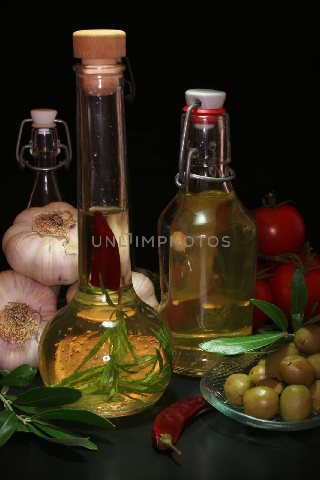 Herbal oil with olive branch and fresh olives and pepperoni