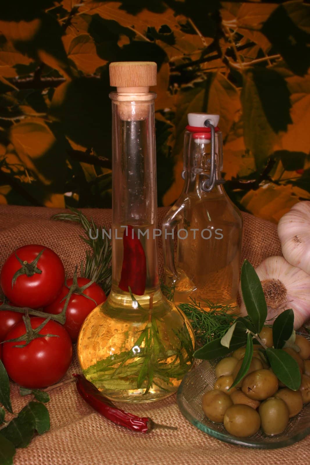 Herbal oil with olive branch and fresh olives and pepperoni