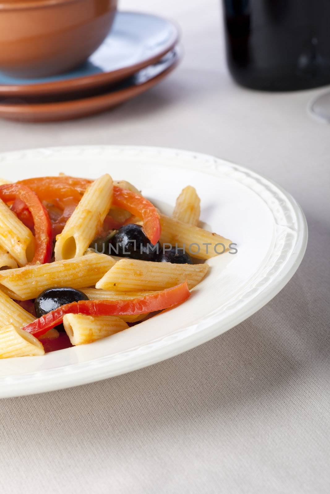 Penne pasta dinner with red bell peppers and black olives