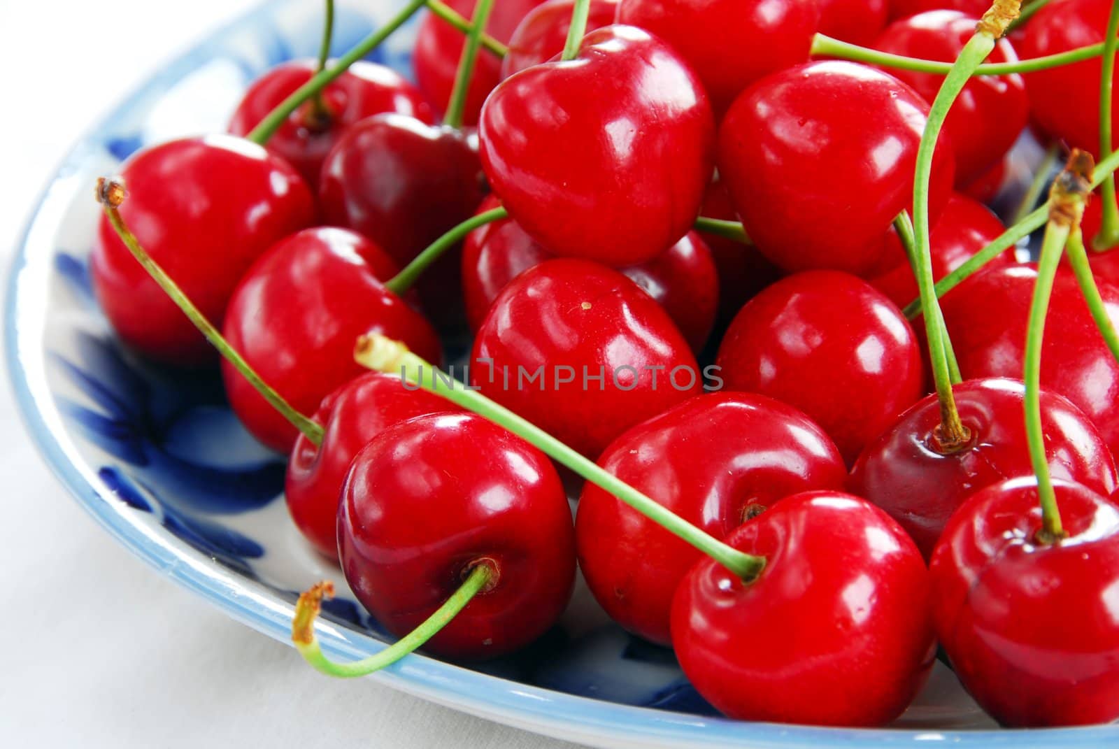 appetizing red fresh ripe cherries on blue plate