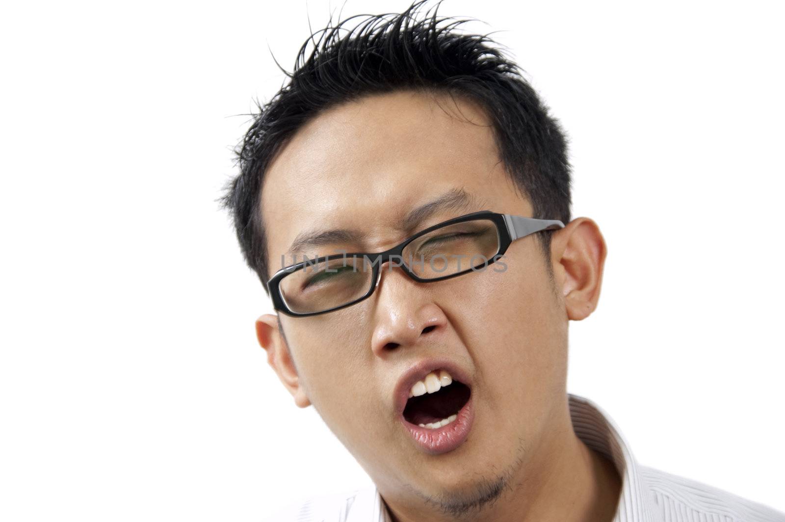 Tired Asian male executive yawning, close up on face.