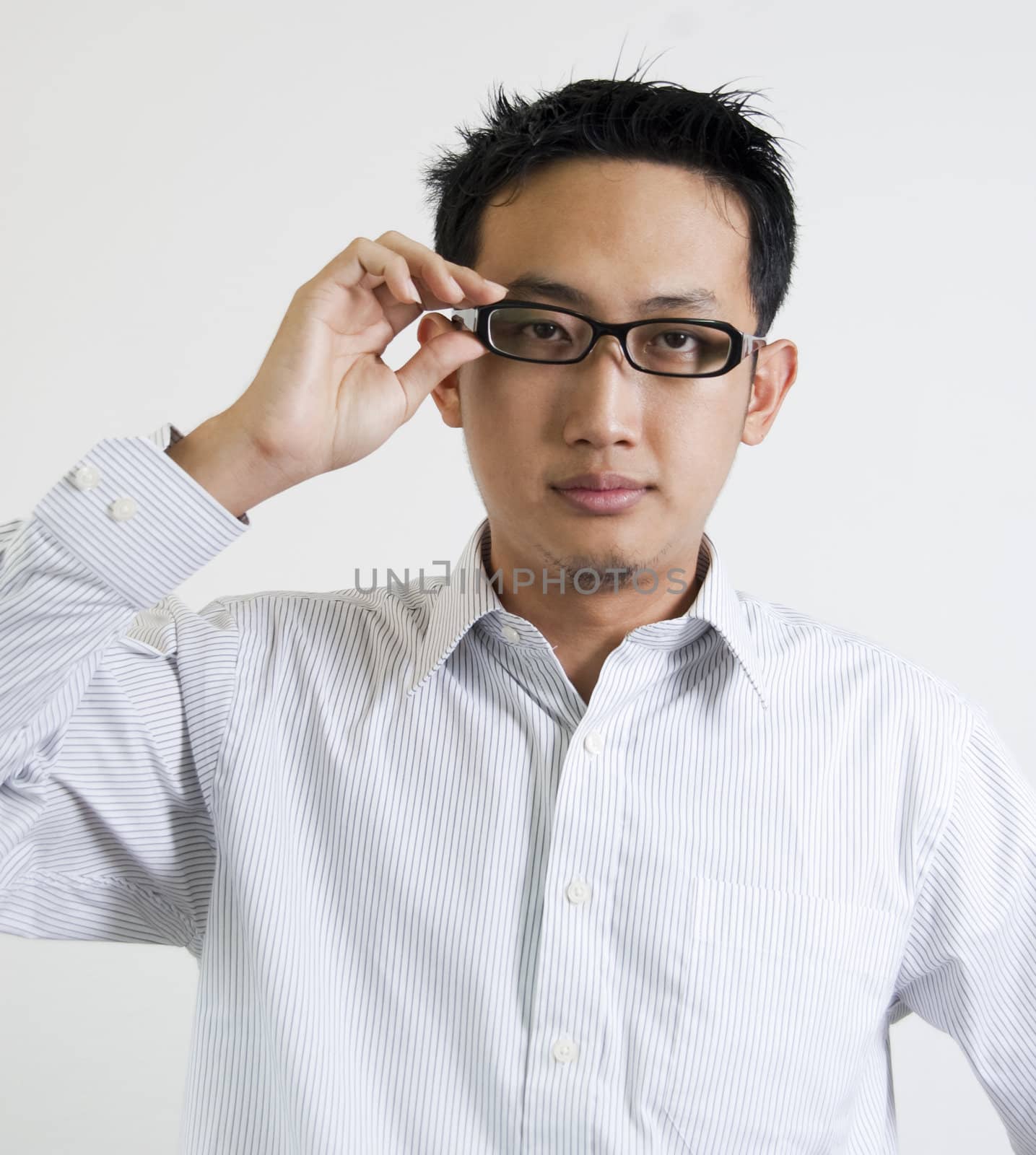 Young Asian executive is adjusting his spectacles