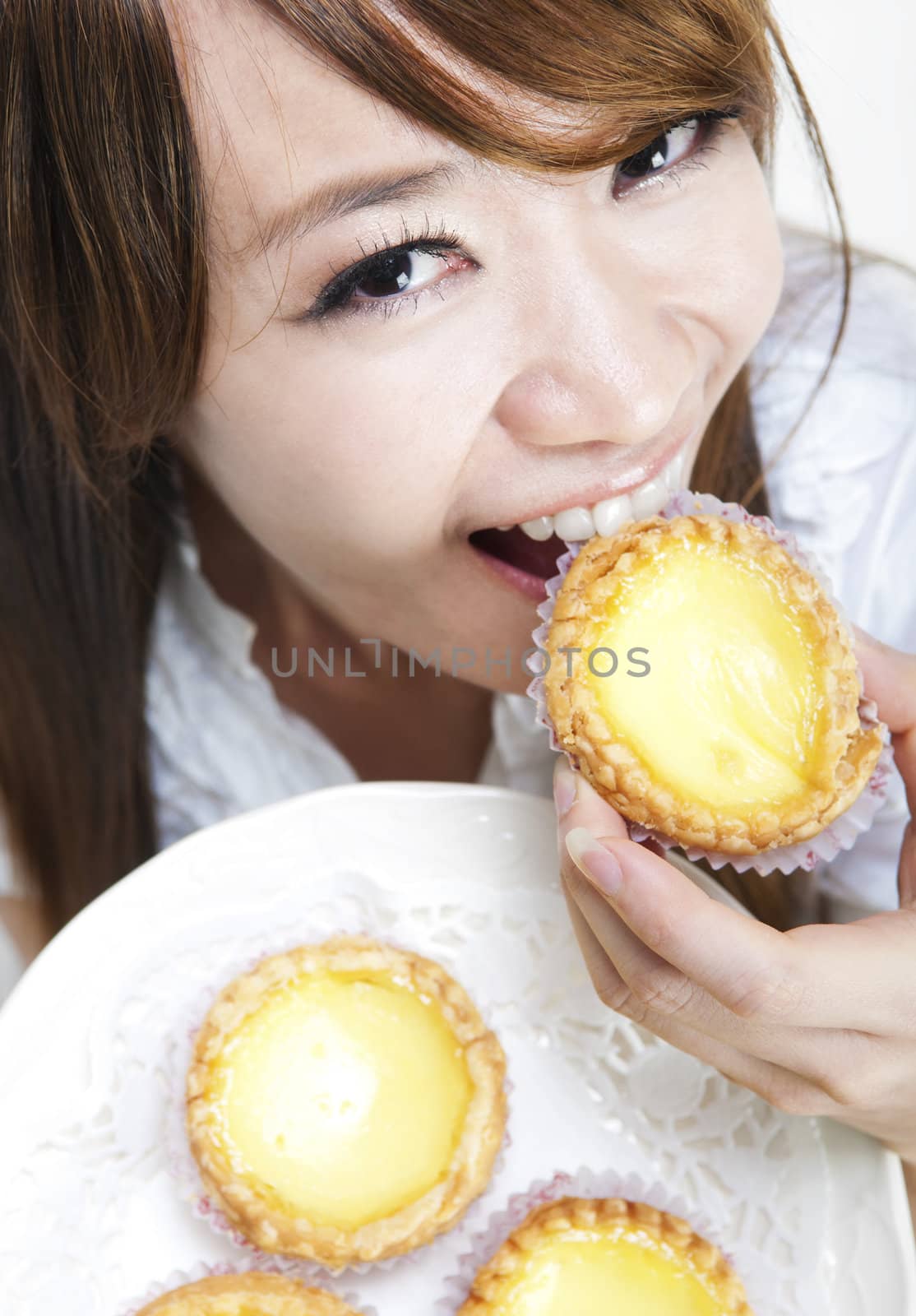 Close up young woman enjoying egg tart