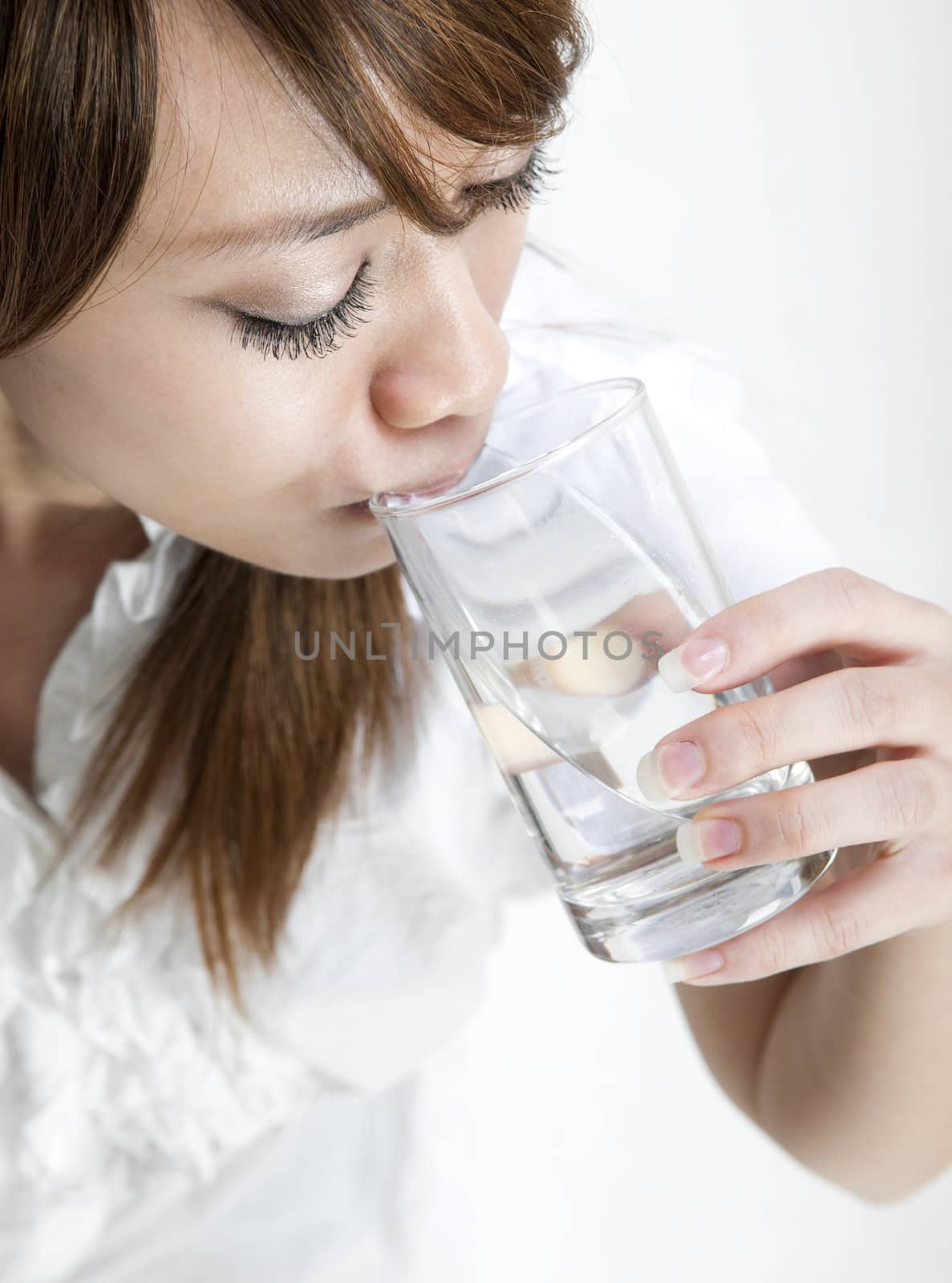 Young girl drinking a glass of mineral water