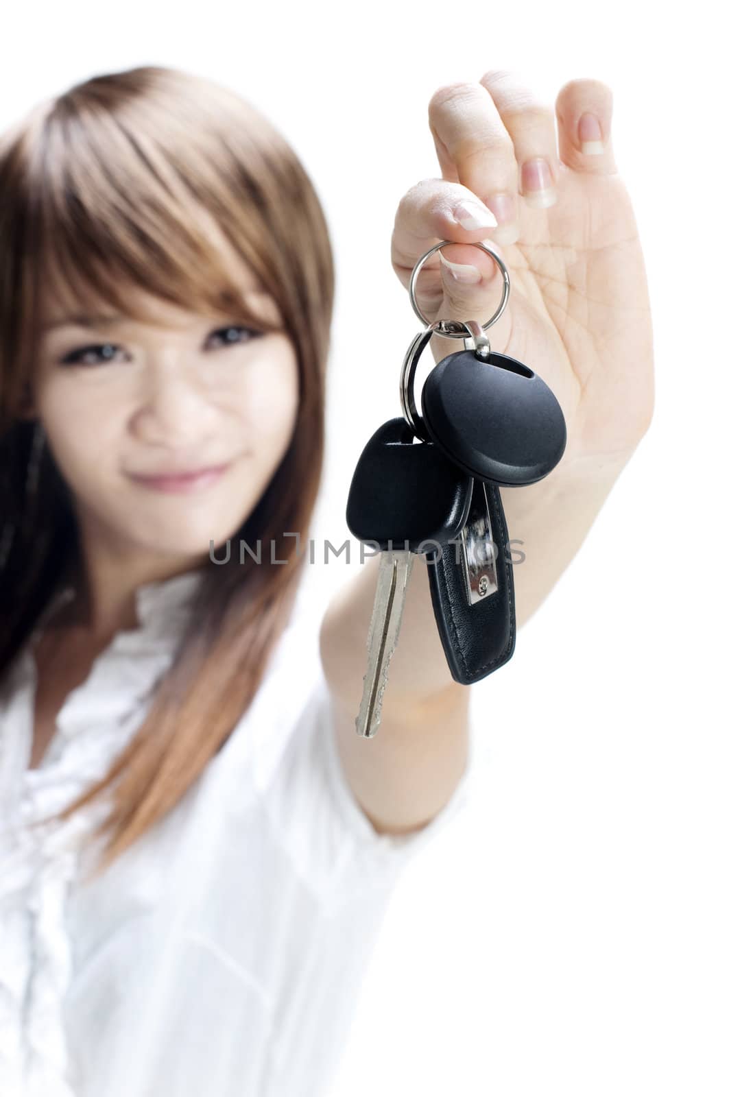 Young woman holding her first own car key on white background, focus on car key.