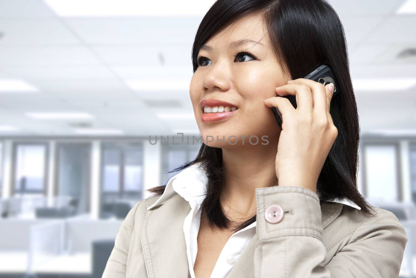 Asian Businesswoman on the phone inside of office.