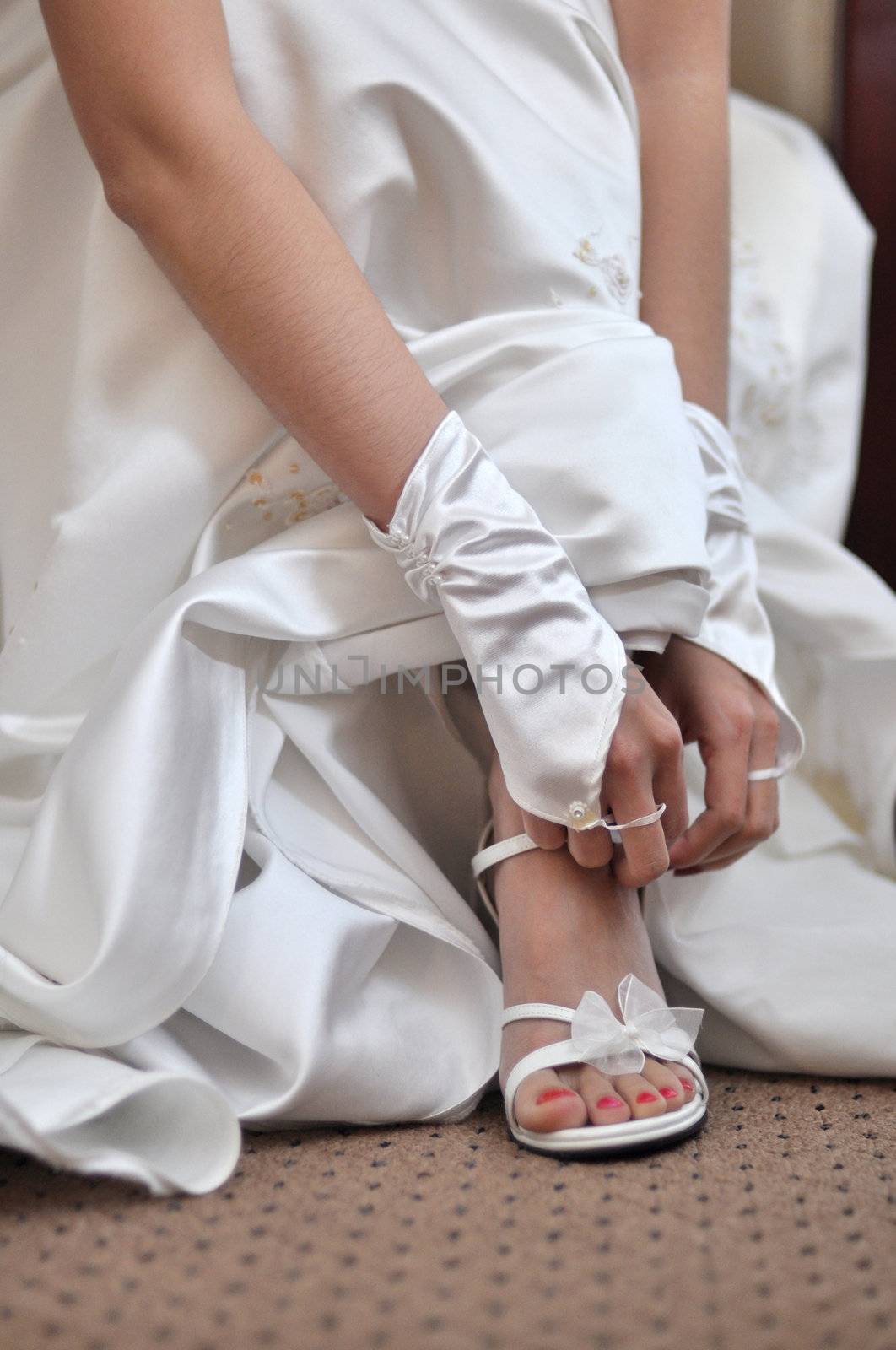 Bride is putting on her wedding shoes