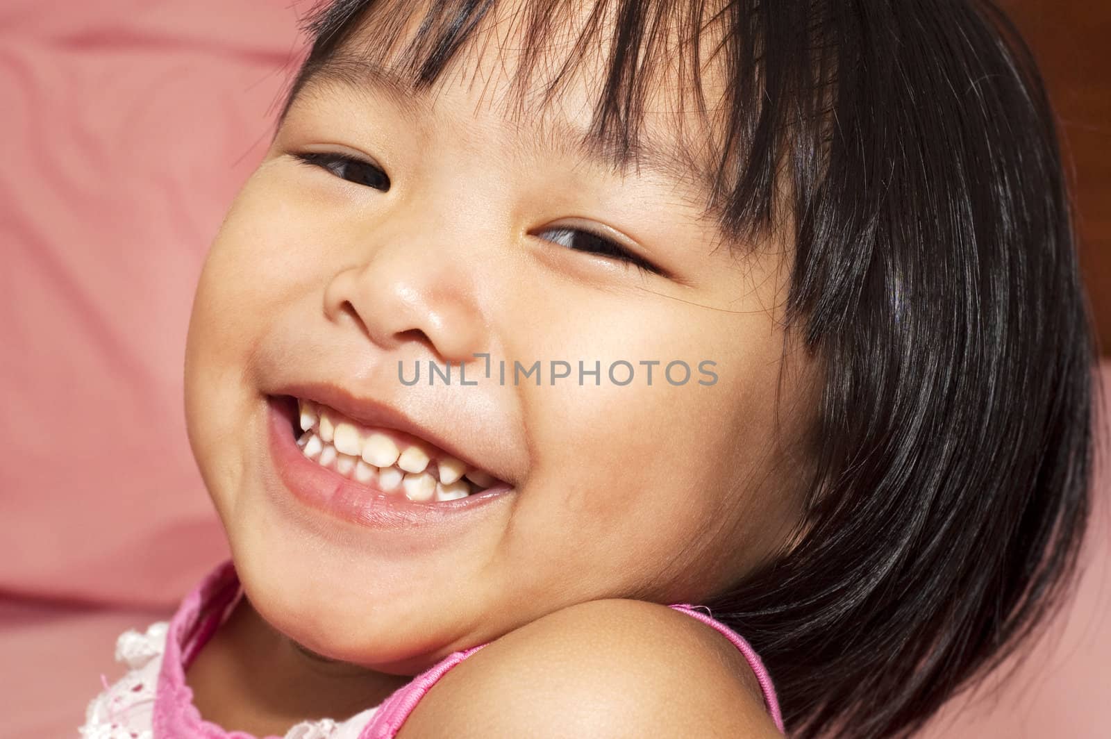 Close-up shot of a young Asian girl with smile on her face.