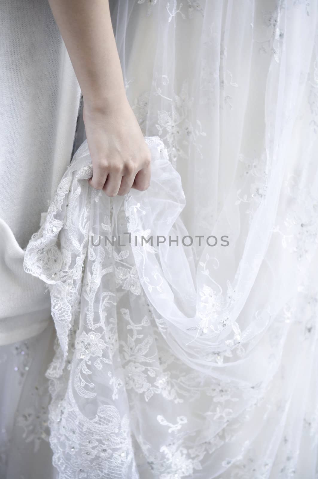 Bridemaid holding bride's wedding dress