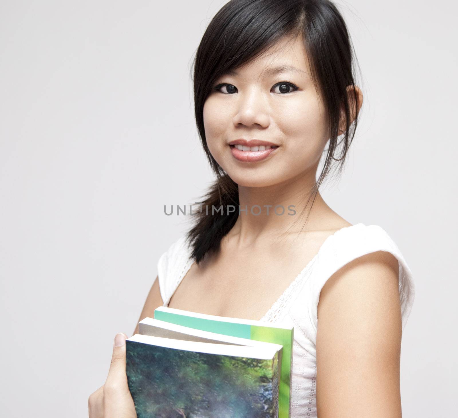 Portrait of young Asian woman with books