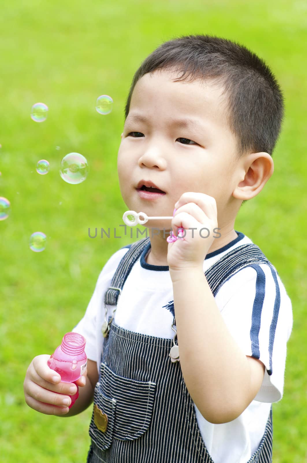 Asian boy blowing bubbles outdoor