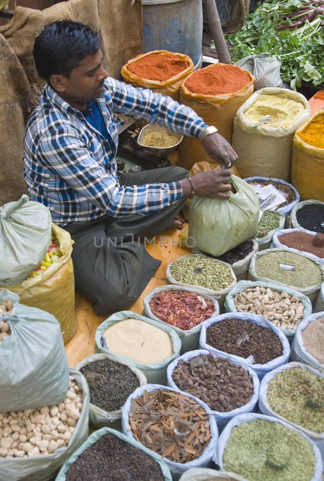 Man selling spices from a pavement stall in Old Delhi, India.