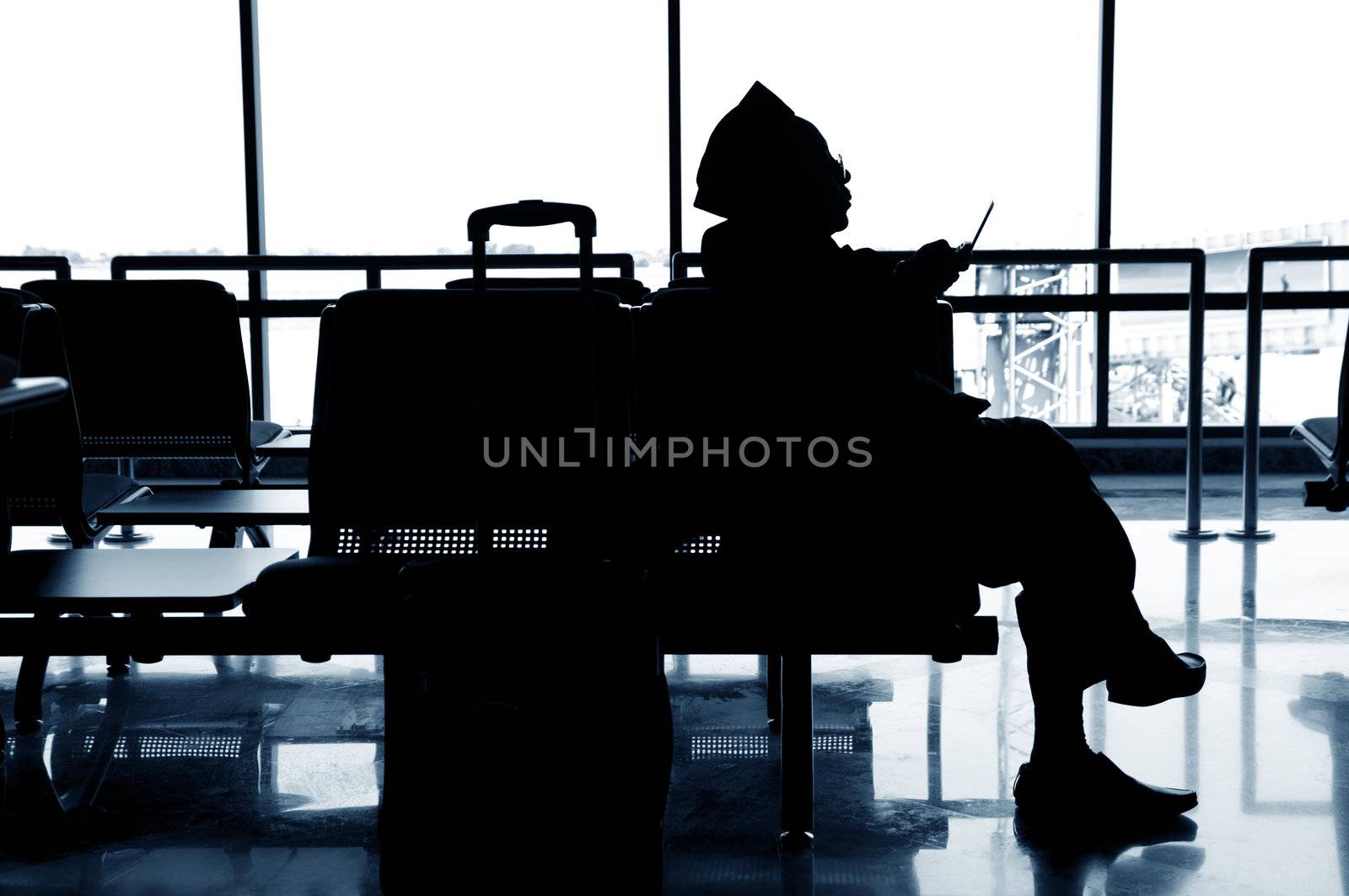 Islamic Man with mobile phone in airport.