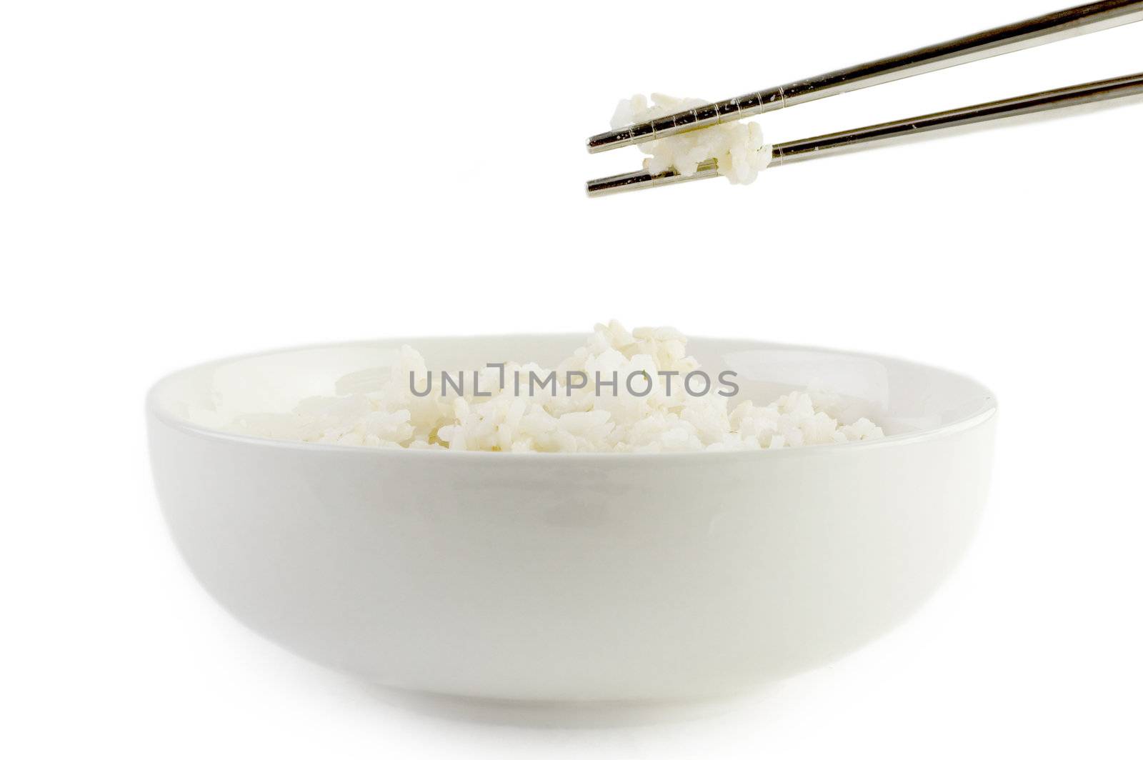 A bowl of cooked brown rice, in an Asian style bowl, with chopsticks isolated on white 