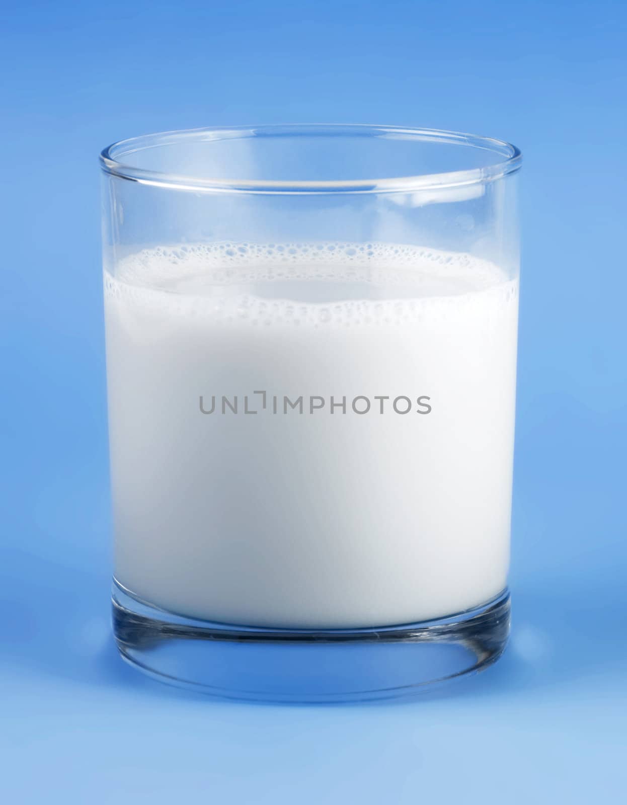 Glass of milk isolated on blue background 