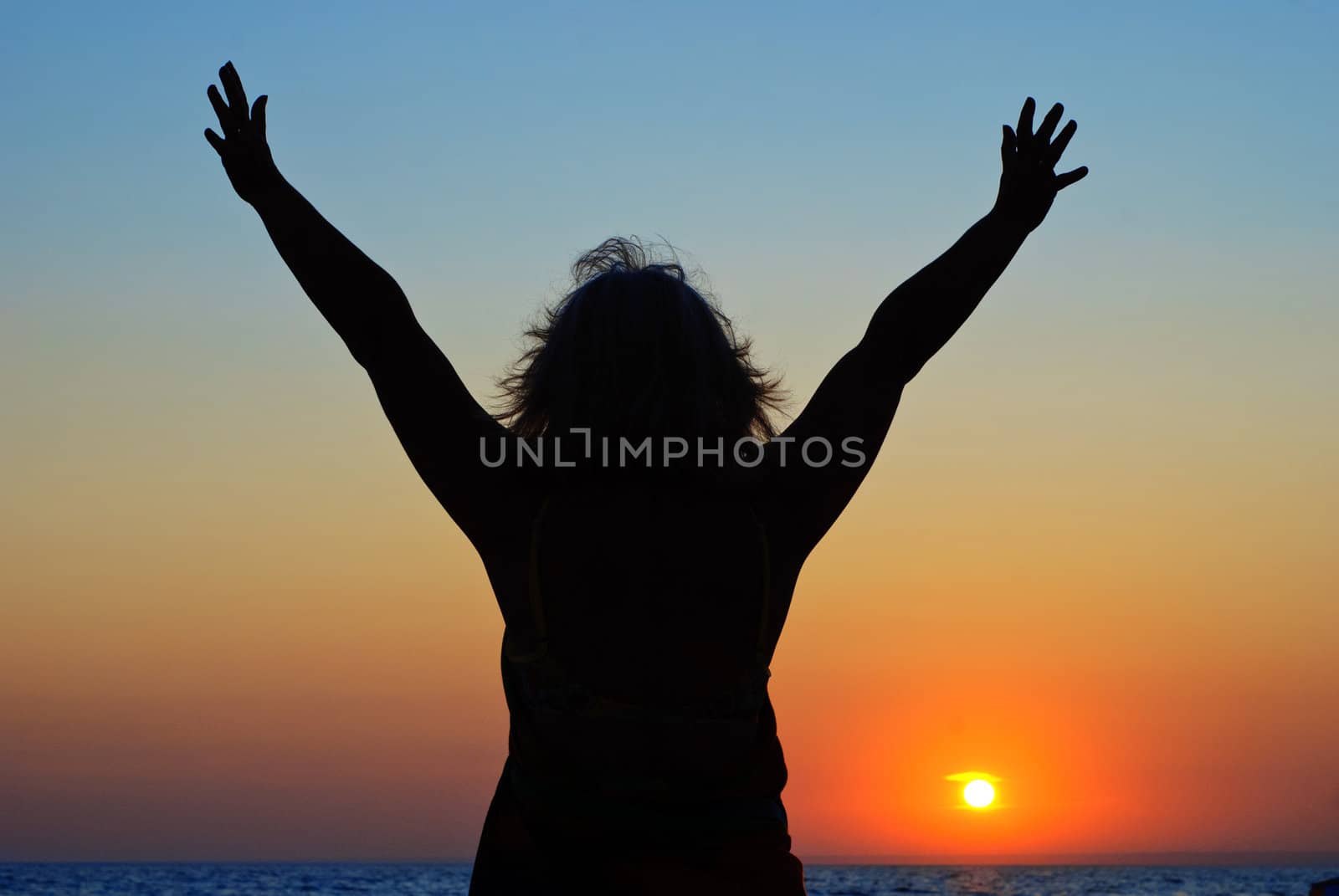 Happy woman on the beach at dawn