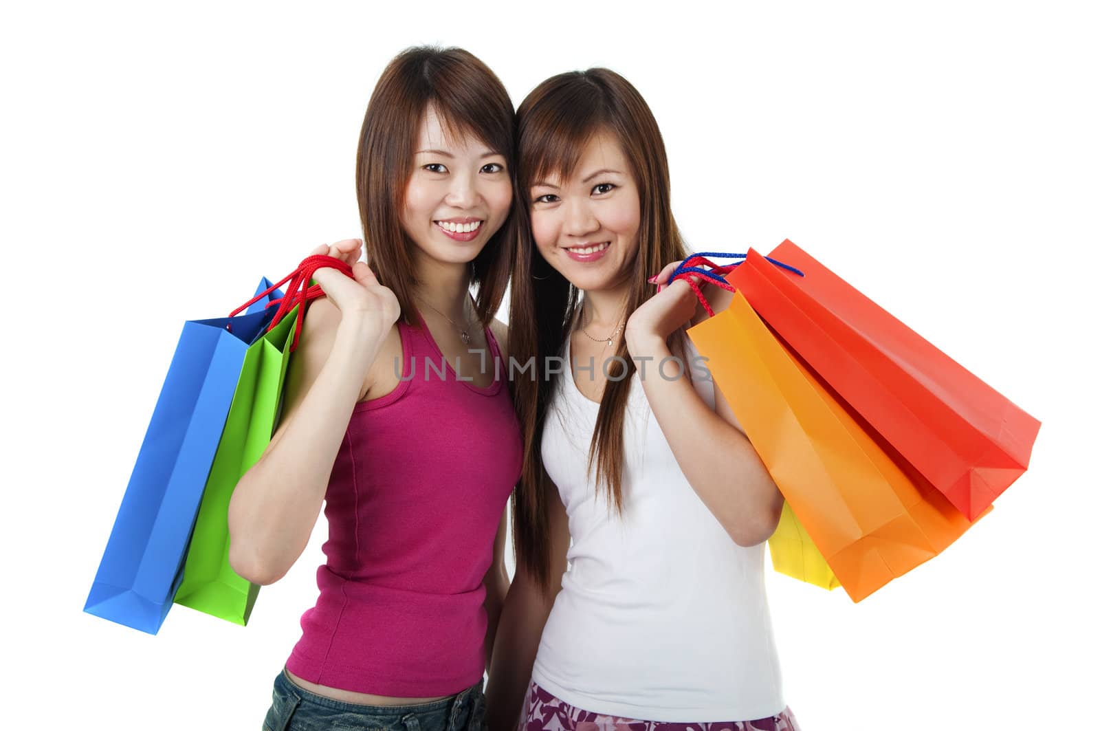 Happy Asian girls standing with shopping bags against white background.