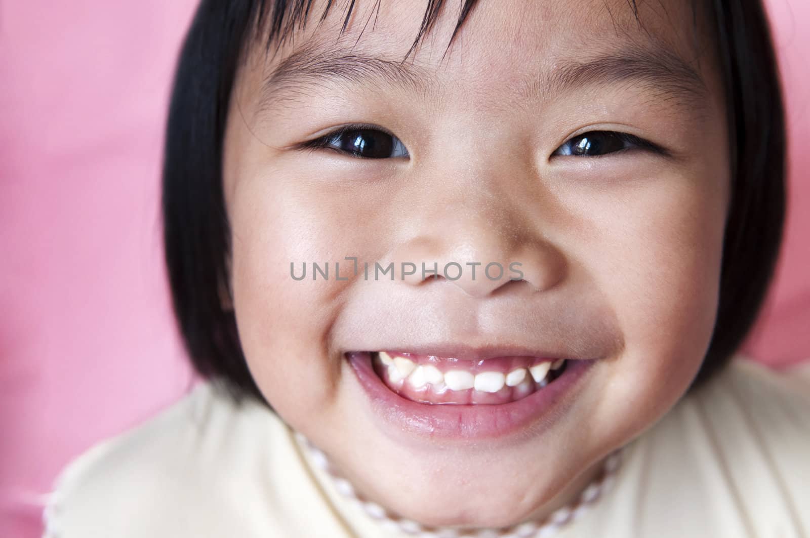 Close-up shot of a young Asian girl with smile on her face. 