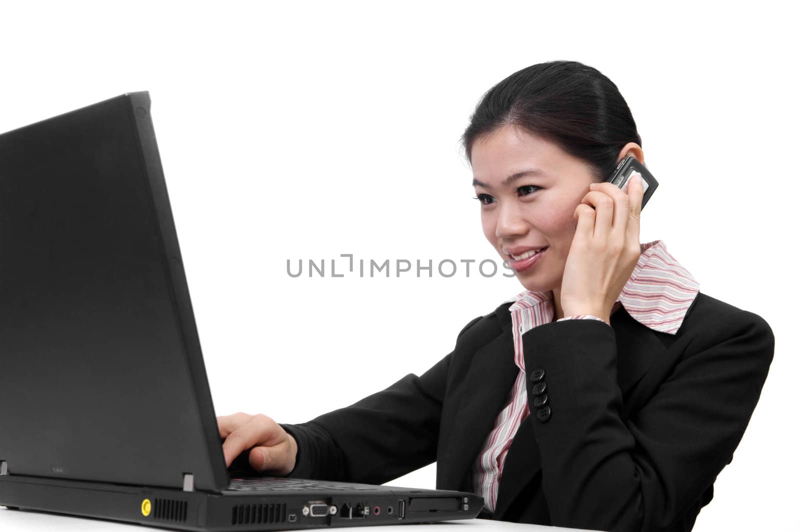 Asian businesswoman on the phone and working on her laptop 
