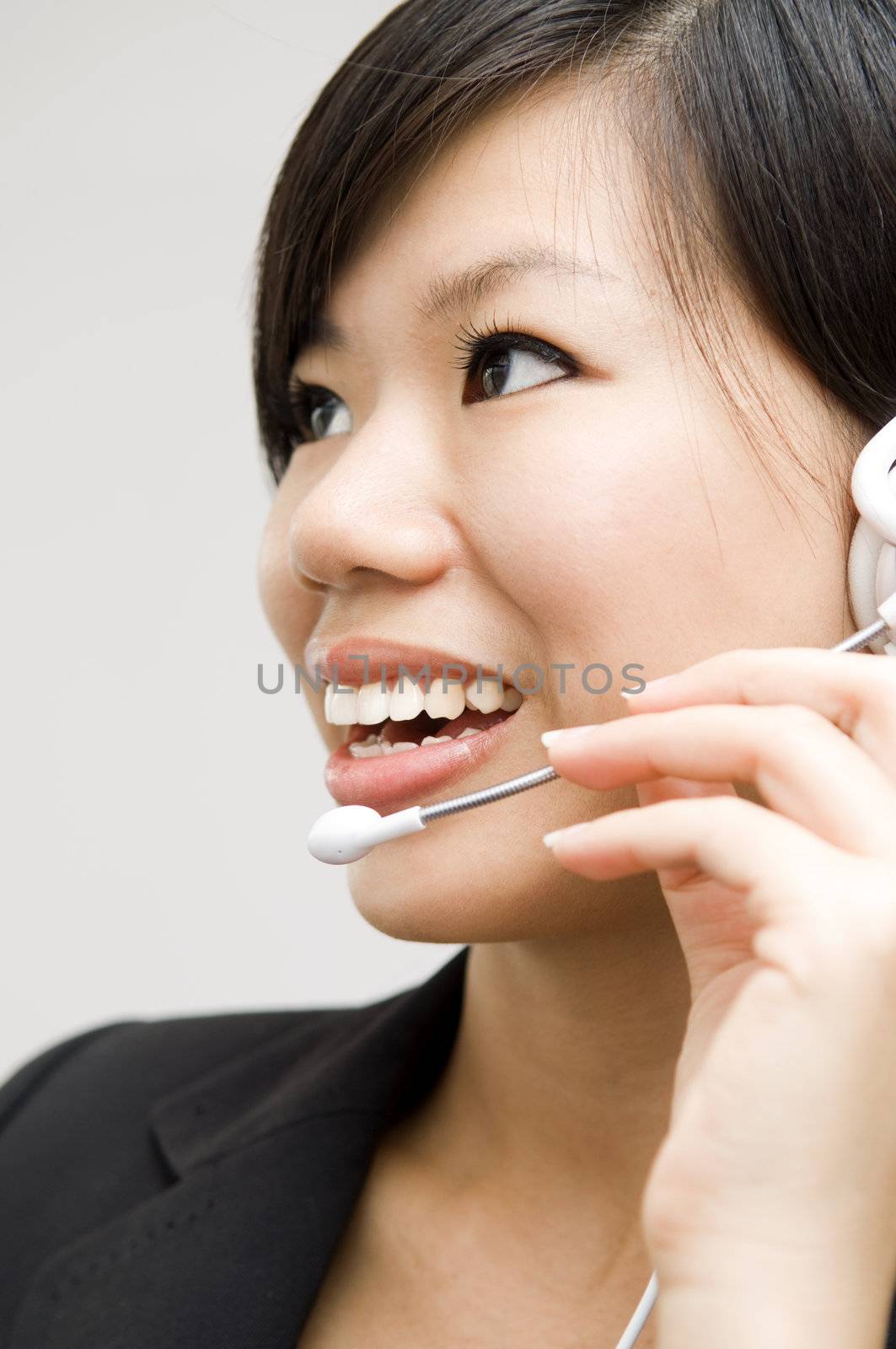 Friendly Customer Representative with headset smiling during a telephone conversation.
