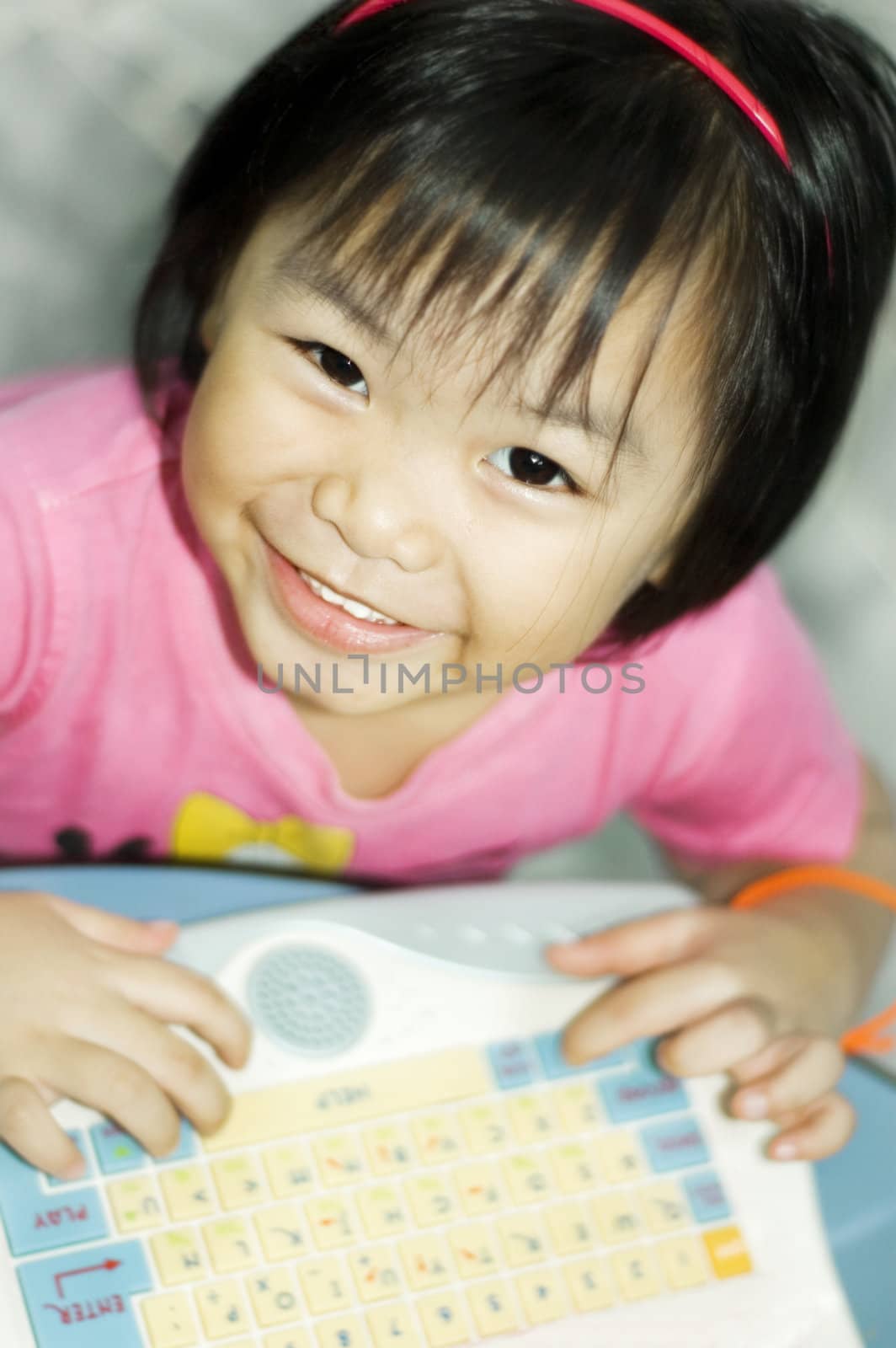 Little asian girl with computer. 
