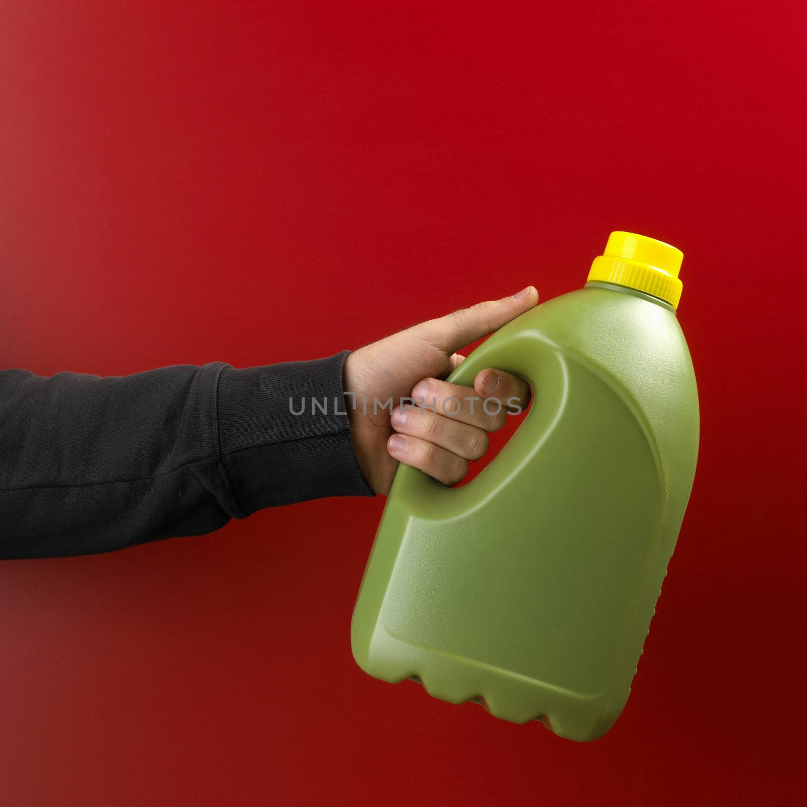Hand with plastic bottle on red background