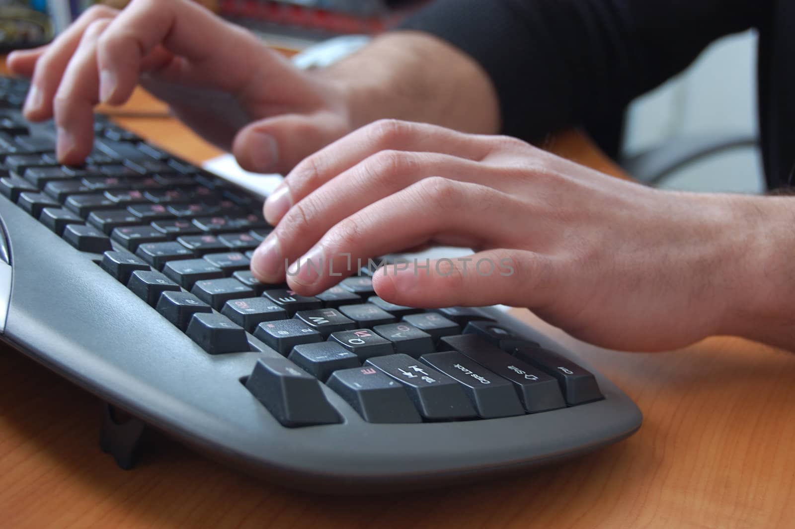 male hand typing on black keyboard