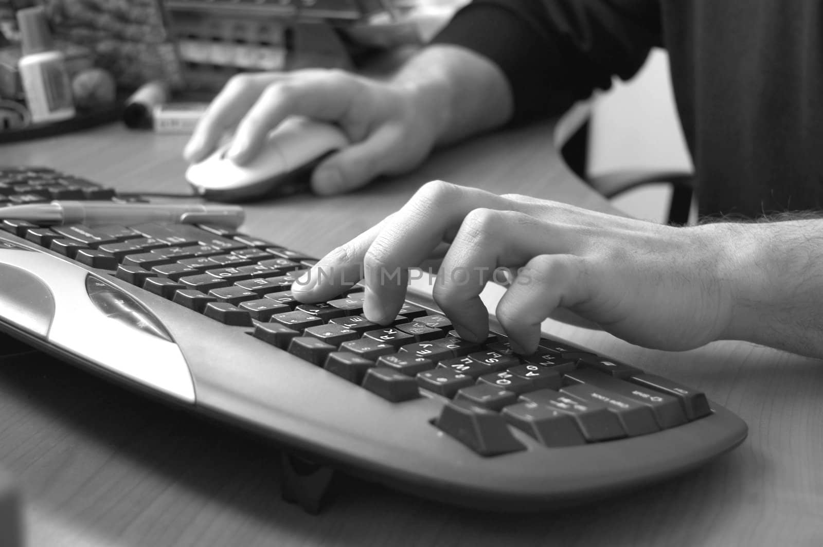 male hand typing on black keyboard, black and white image