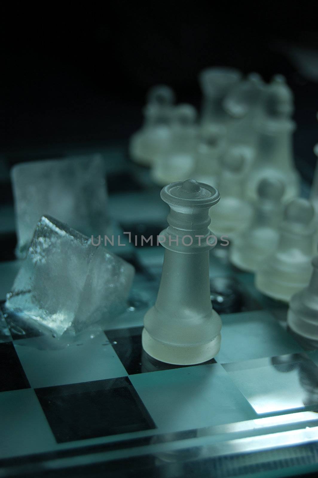 Set of glass chess, queen and ice on board