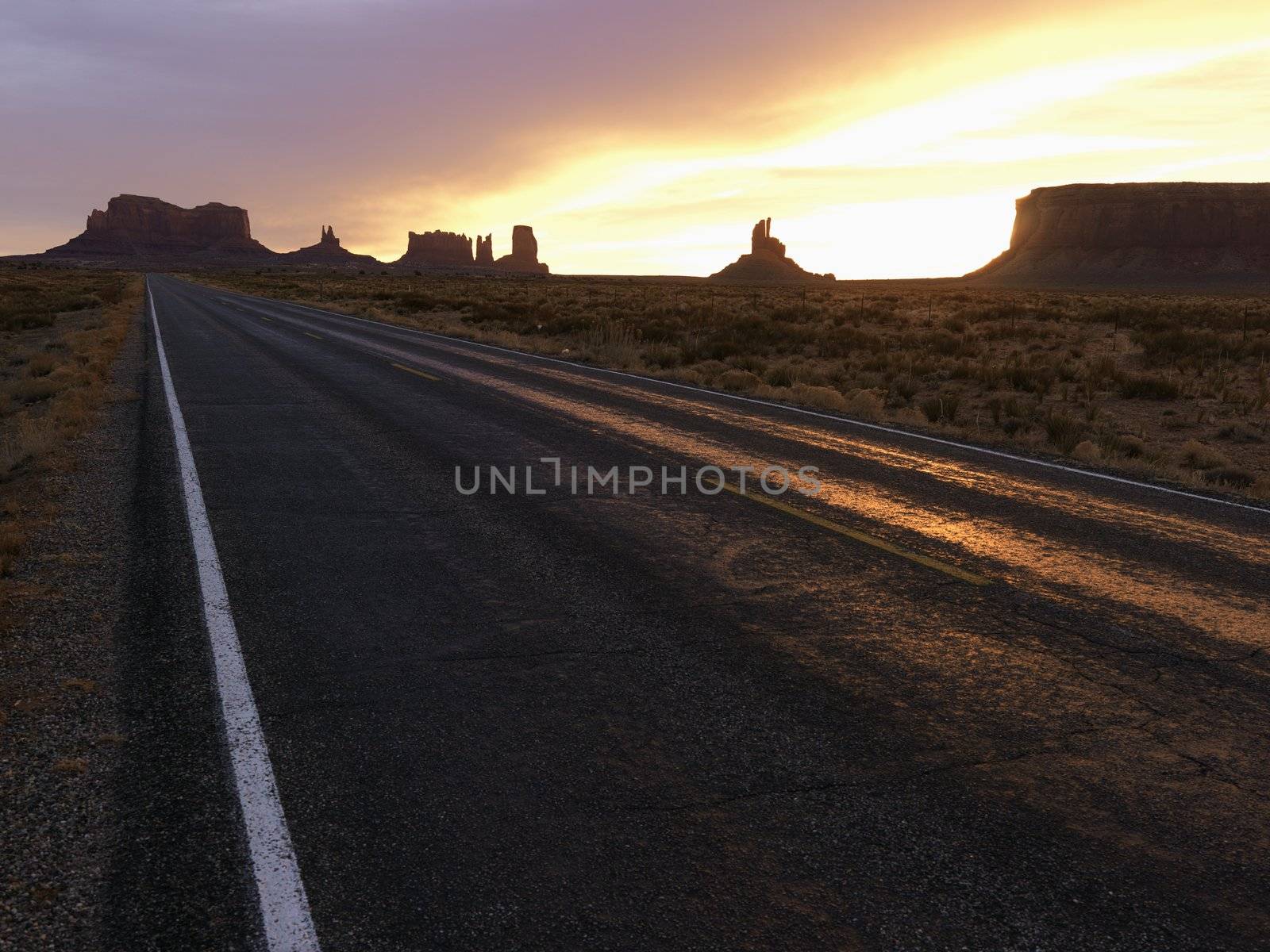 Sunset on highway in Monument Valley. by iofoto