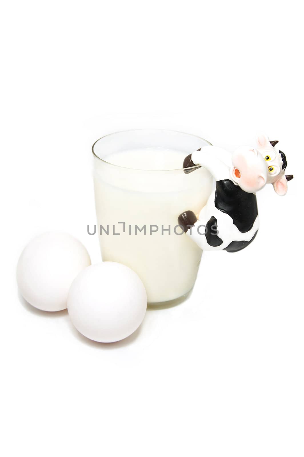 Glass of milk, eggs and funny toy cow