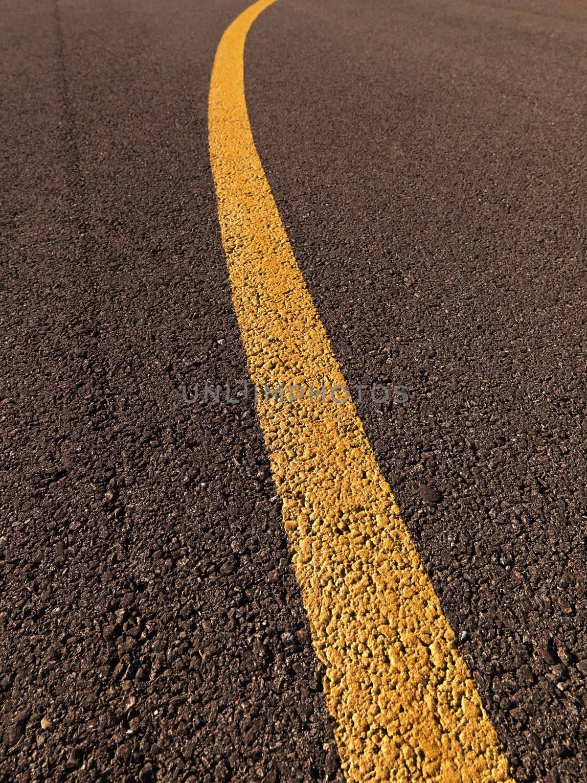 Close up of yellow line on asphalt.