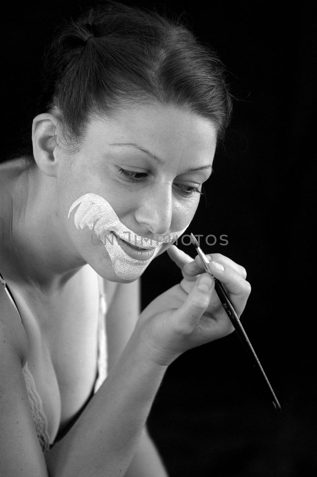 black and white photo of clown putting on make up