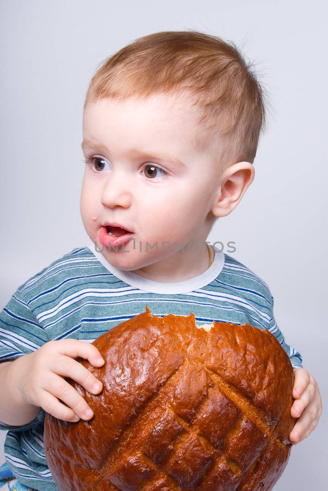 A little Caucasian boy eating a bread by Fanfo