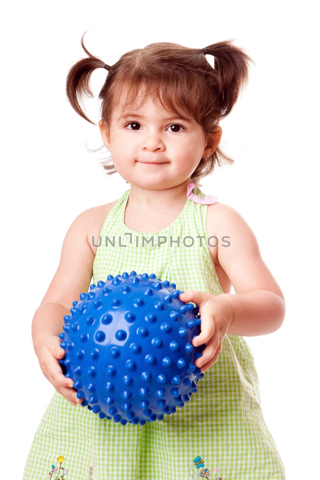 Beautiful cute happy toddler baby girl in green dress playing with blue spiky ball, isolated.