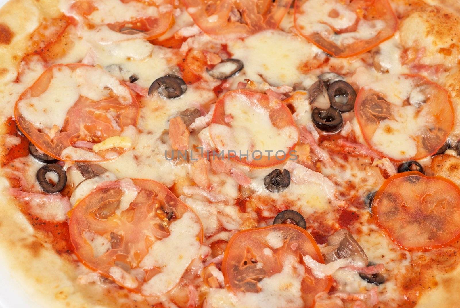meat pizza closeup with carbonado ham, tomato, olive and mozzarella cheese
