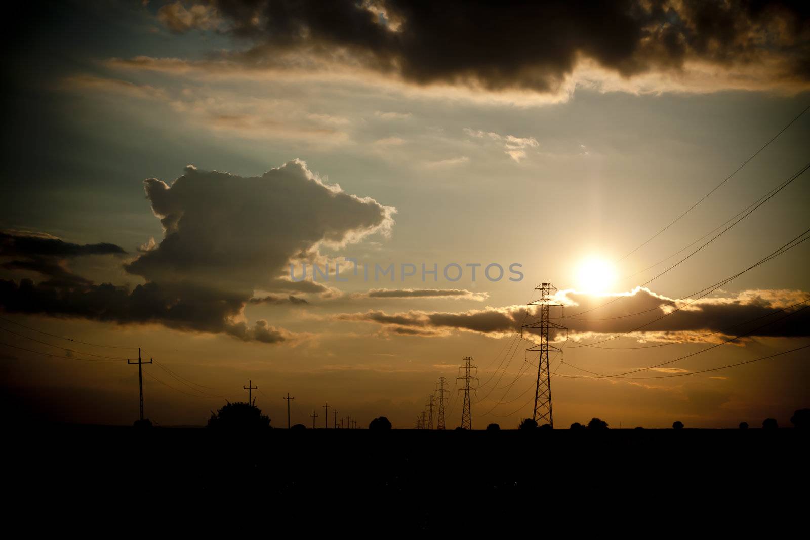 landscape with high tension wires over sky