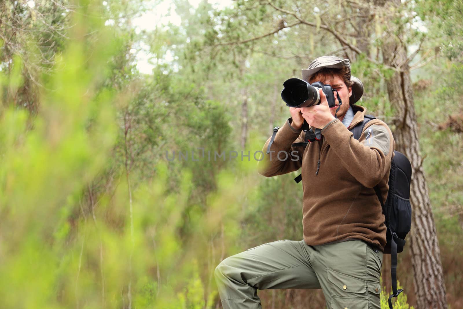 Nature photographer in forest taking pictures. Man with DSLR camera and hiking outfit. From Aguamansa, Tenerife, Spain