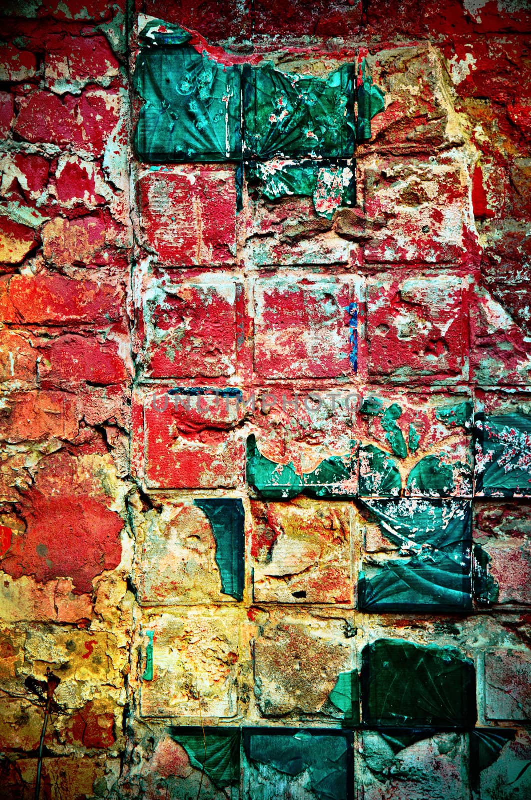Background in style grunge. Multi-colored wall with a beaten tile of green color