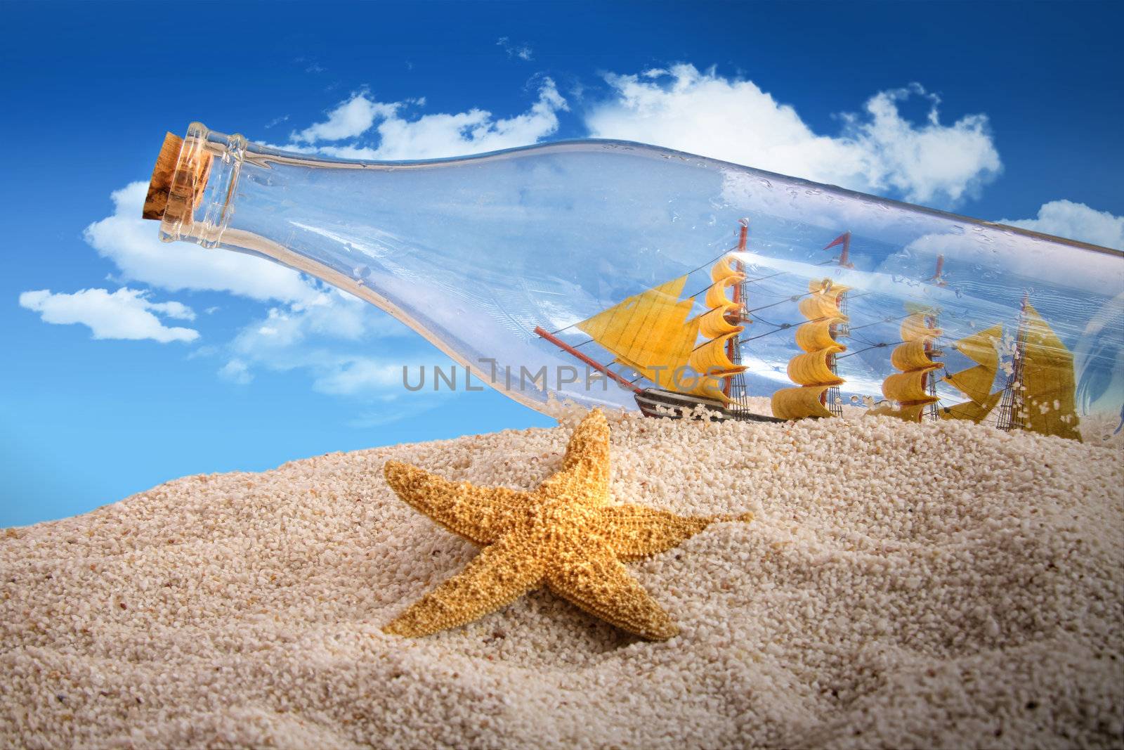 Ship in a bottle on  pile of sand at the beach